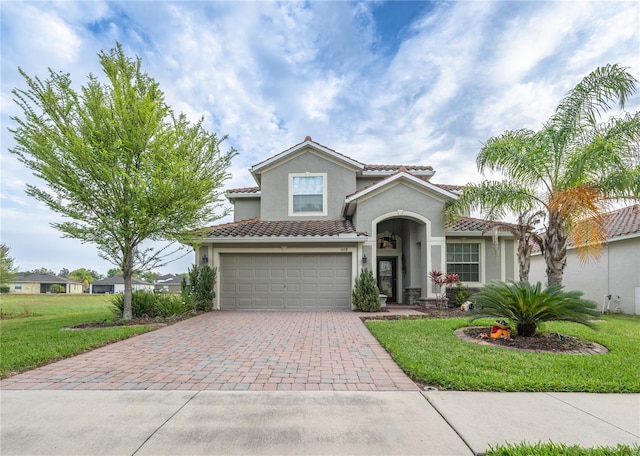 mediterranean / spanish-style home featuring a front yard and a garage