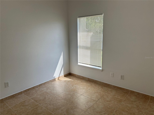 spare room with light tile patterned floors and a wealth of natural light