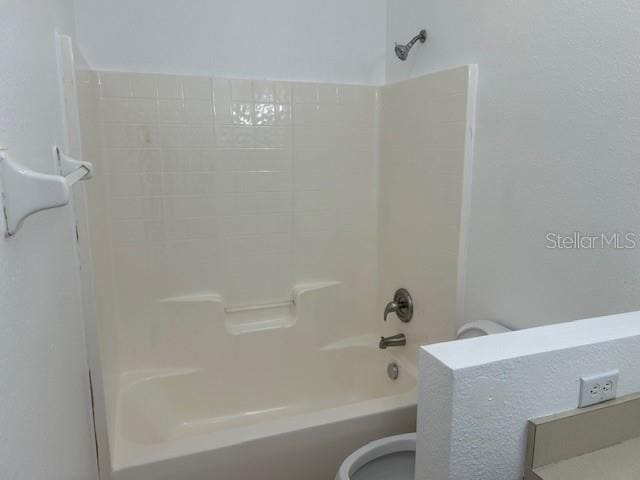 bathroom featuring shower / bath combination and toilet