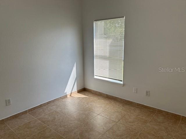 tiled empty room featuring plenty of natural light