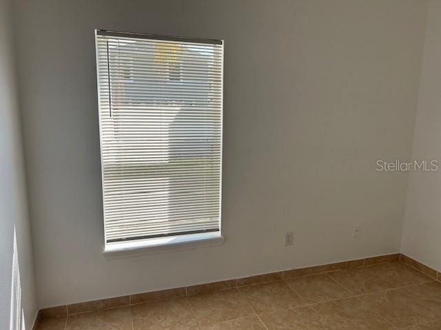 tiled empty room featuring a healthy amount of sunlight