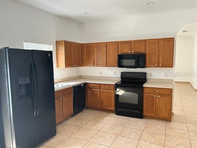 kitchen with black appliances and light tile patterned flooring