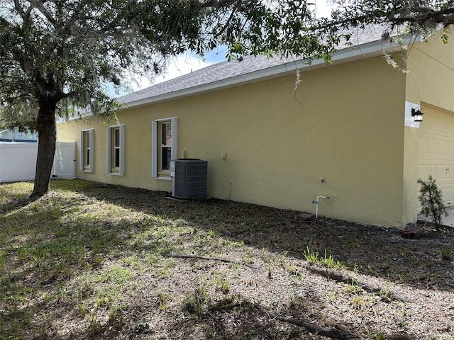 back of property featuring cooling unit and a garage