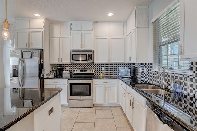 kitchen with dark stone countertops, white cabinets, and stainless steel appliances