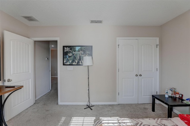 carpeted bedroom with a closet and a textured ceiling