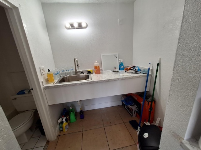 bathroom featuring tile flooring, toilet, and sink