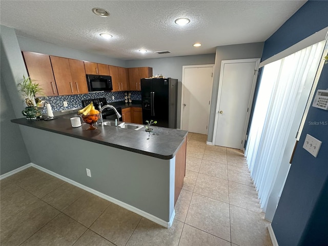 kitchen featuring kitchen peninsula, sink, light tile floors, black appliances, and tasteful backsplash