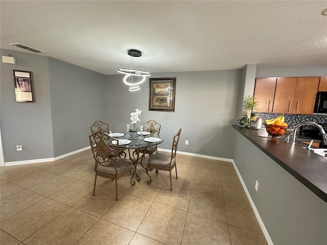 tiled dining space featuring a notable chandelier and sink