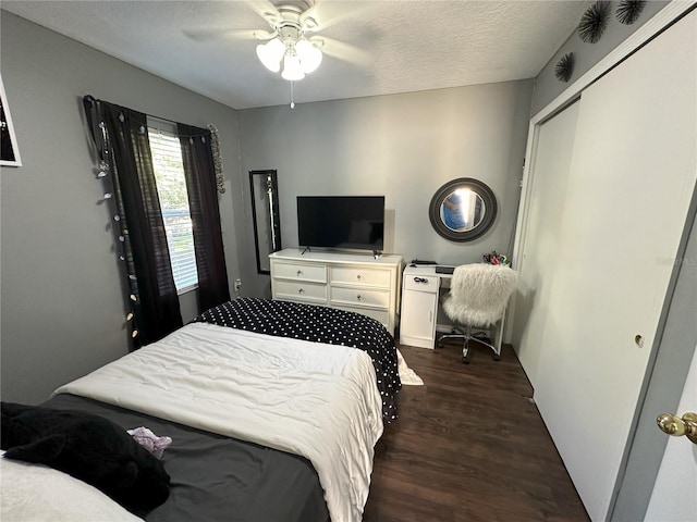 bedroom featuring a textured ceiling, a closet, ceiling fan, and dark hardwood / wood-style floors