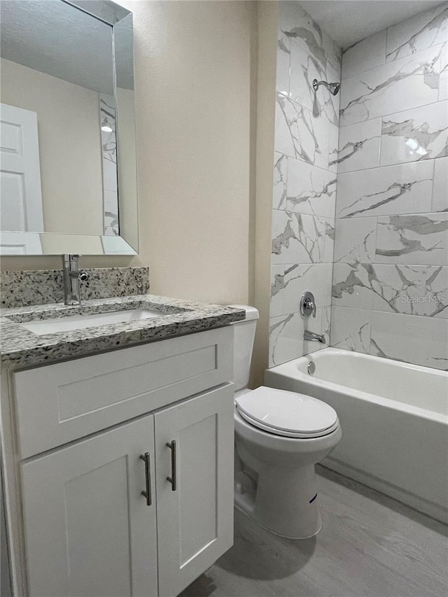 full bathroom with vanity, toilet, and tiled shower / bath