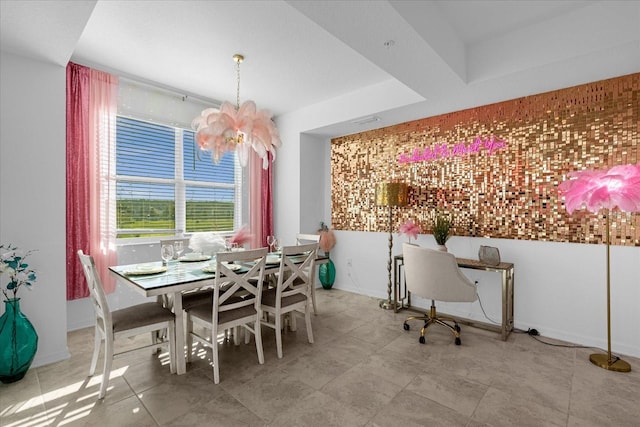 dining room featuring light tile floors, a notable chandelier, and a tray ceiling