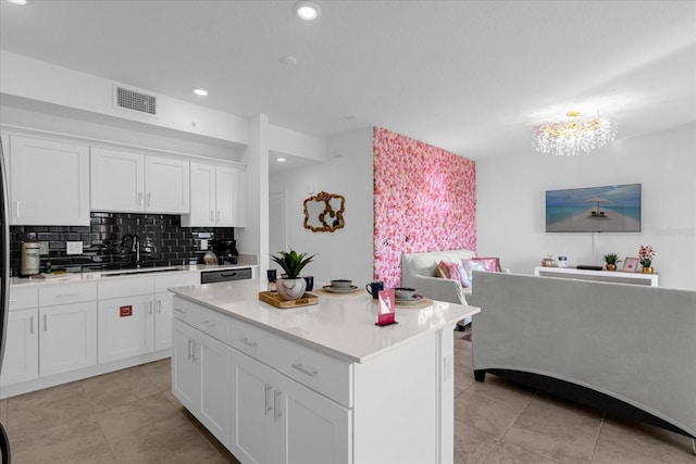 kitchen featuring a center island, white cabinetry, a chandelier, and backsplash