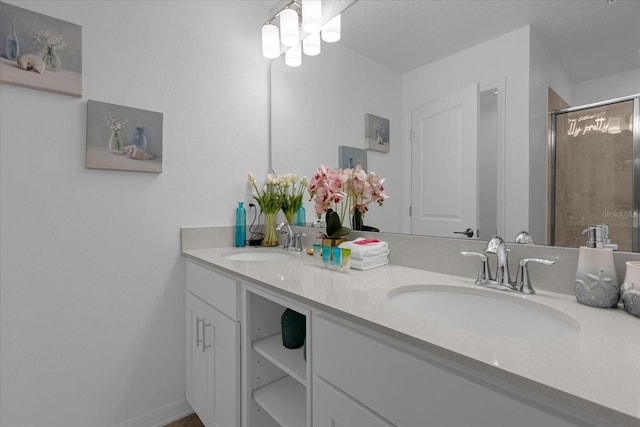 bathroom with double sink vanity and a shower with shower door