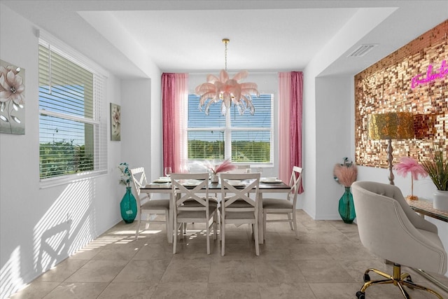 dining space featuring an inviting chandelier and light tile flooring