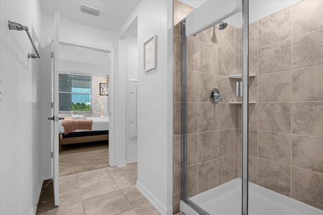 bathroom with a shower with door and tile flooring