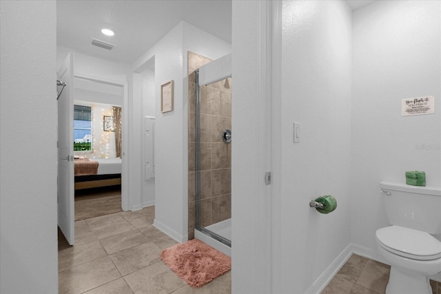 bathroom featuring toilet, tile floors, and an enclosed shower