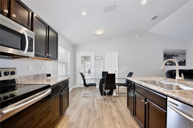 kitchen with lofted ceiling, appliances with stainless steel finishes, sink, light wood-type flooring, and dark brown cabinetry