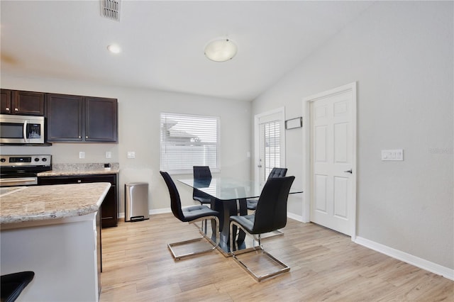 kitchen with appliances with stainless steel finishes, lofted ceiling, dark brown cabinetry, and light hardwood / wood-style floors