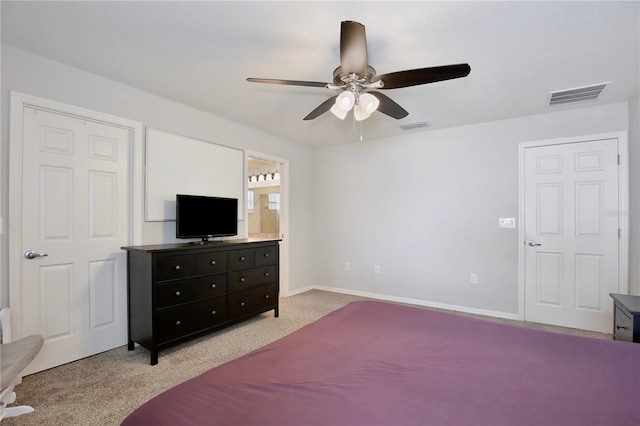 bedroom with ceiling fan, connected bathroom, and light colored carpet