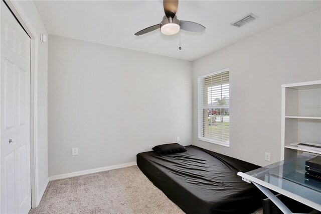 bedroom featuring light carpet, a closet, and ceiling fan