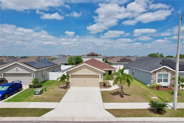 ranch-style home featuring solar panels, a front yard, and a garage