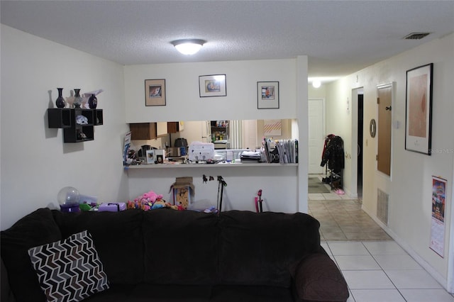 interior space with a textured ceiling and light tile floors