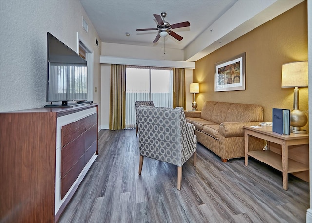 living room featuring ceiling fan and hardwood / wood-style flooring