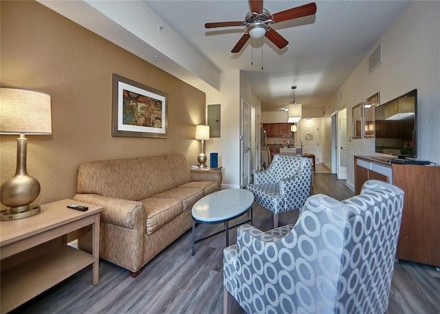 living room with ceiling fan and dark hardwood / wood-style flooring