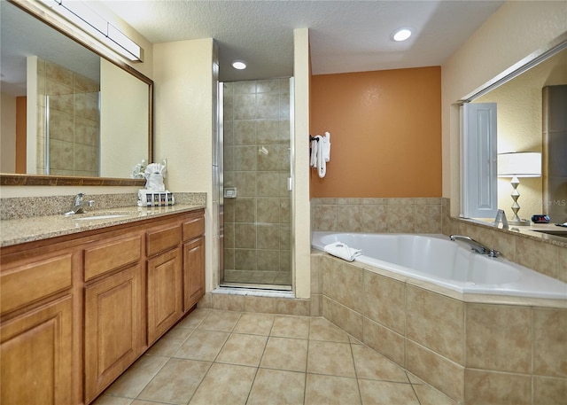 bathroom featuring independent shower and bath, a textured ceiling, tile flooring, and vanity