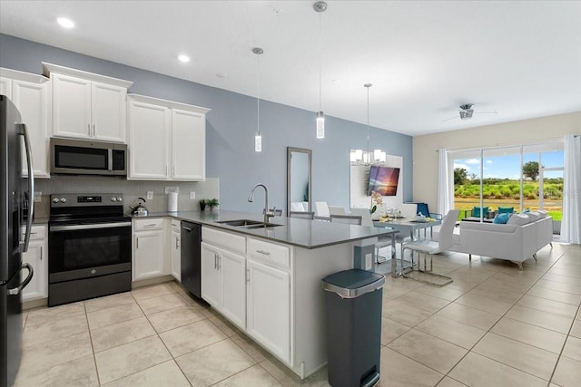 kitchen with kitchen peninsula, sink, hanging light fixtures, white cabinets, and stainless steel appliances