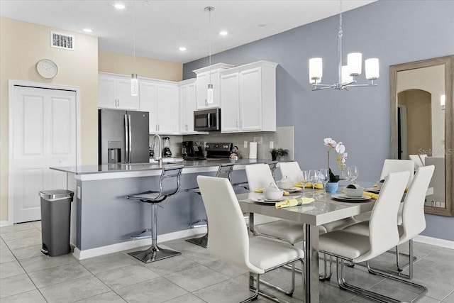 dining area featuring an inviting chandelier, sink, and light tile floors