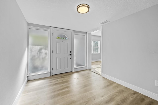 entryway featuring a textured ceiling and light hardwood / wood-style floors