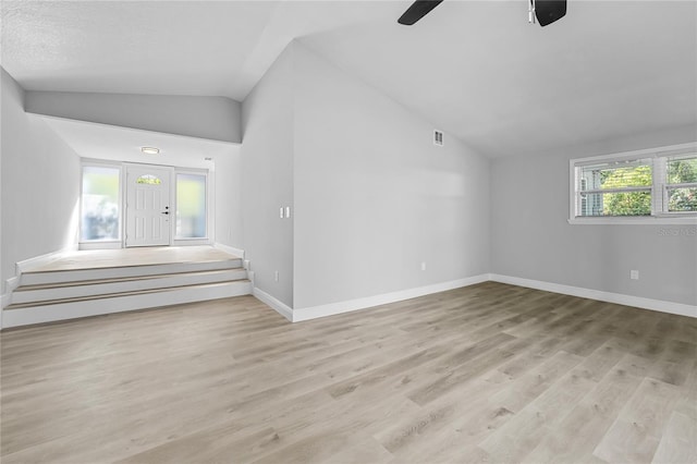 empty room with lofted ceiling, ceiling fan, and light wood-type flooring