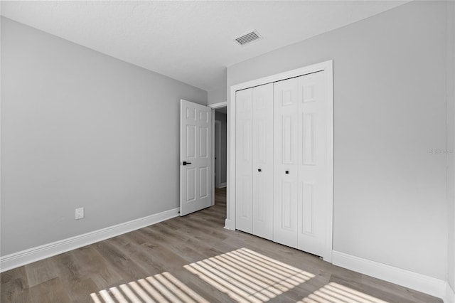 unfurnished bedroom featuring dark hardwood / wood-style flooring and a closet