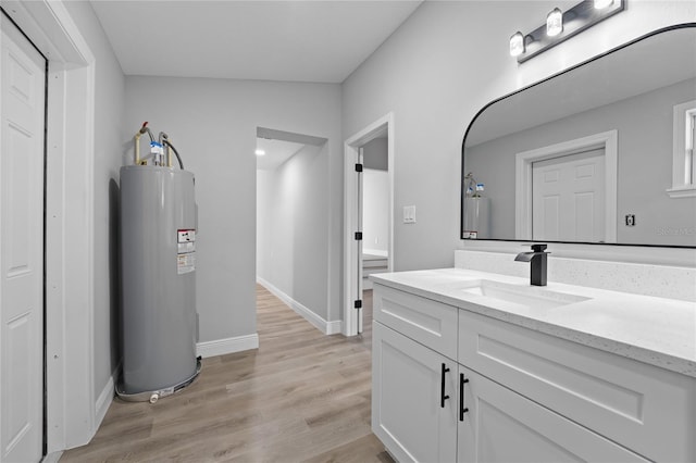 bathroom with water heater, vanity, vaulted ceiling, and hardwood / wood-style floors