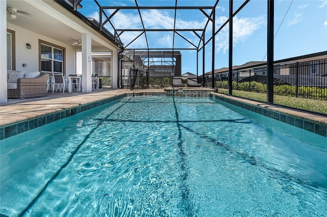 view of pool featuring ceiling fan, a patio area, and glass enclosure