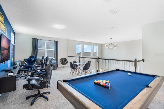 game room featuring a textured ceiling, a notable chandelier, light colored carpet, and pool table