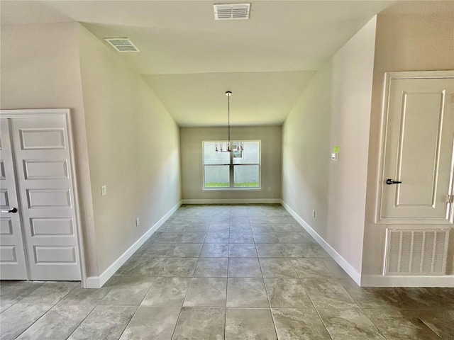 unfurnished room with light tile floors and a chandelier