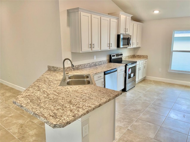 kitchen with kitchen peninsula, sink, light tile floors, appliances with stainless steel finishes, and white cabinetry