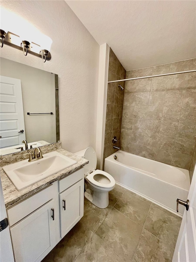 full bathroom with oversized vanity, toilet, tiled shower / bath, and tile flooring