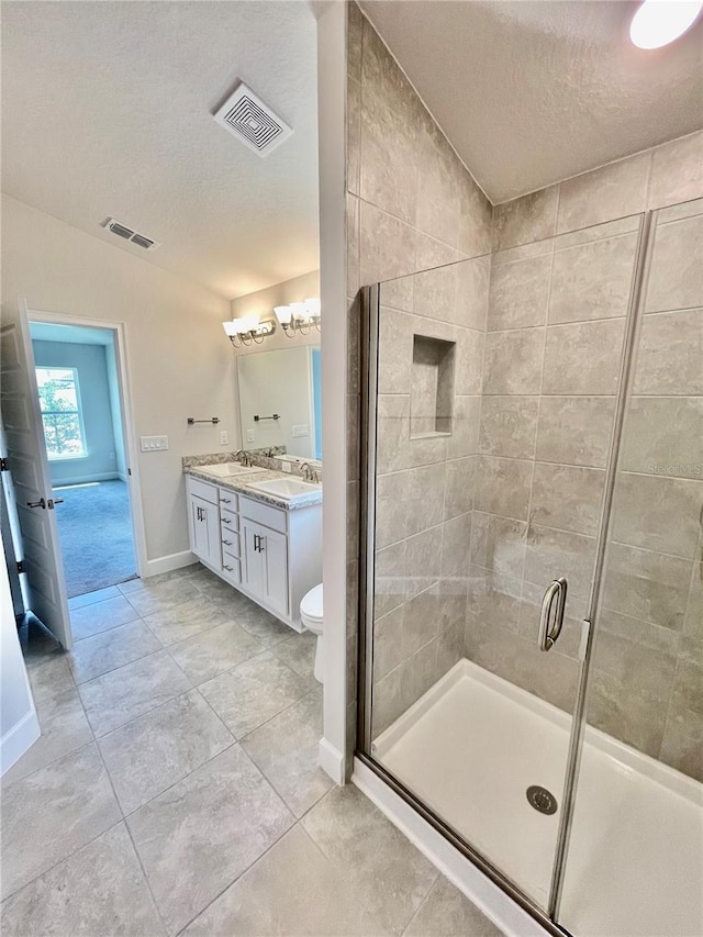 bathroom featuring vanity, tile flooring, a textured ceiling, and toilet