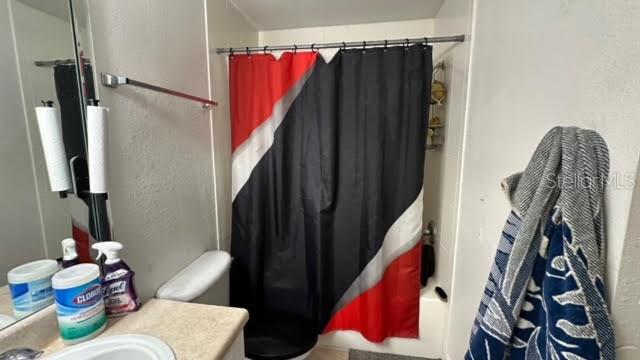 bathroom with shower / tub combo and vanity