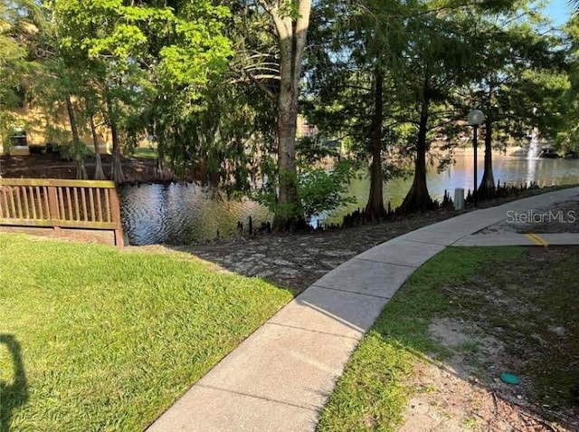 view of home's community featuring a lawn and a water view