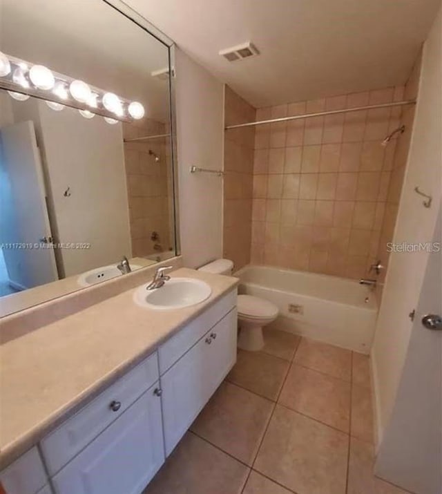 full bathroom featuring tiled shower / bath combo, vanity, tile flooring, and toilet