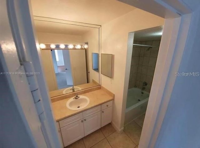 bathroom featuring tiled shower / bath combo, vanity, and tile flooring