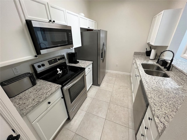 kitchen featuring white cabinets, light tile flooring, and appliances with stainless steel finishes