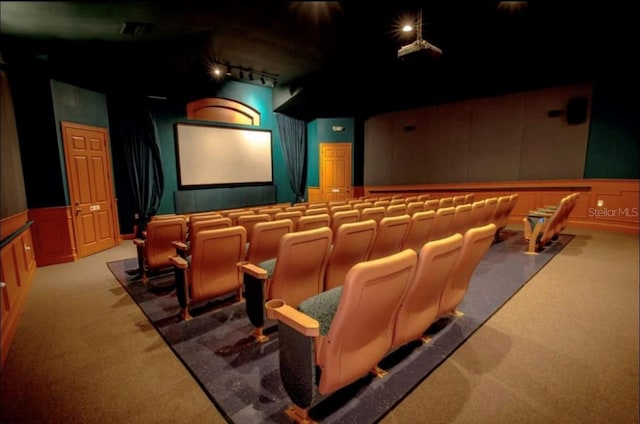 home theater with rail lighting and light colored carpet