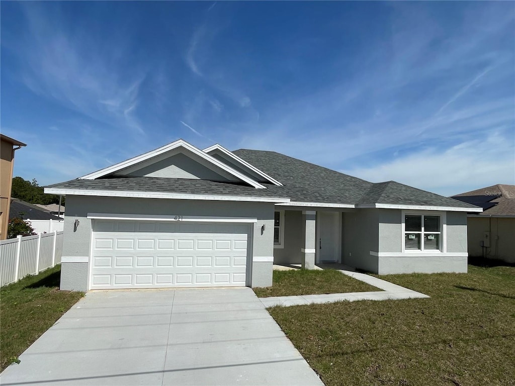 view of front of property with a front yard and a garage