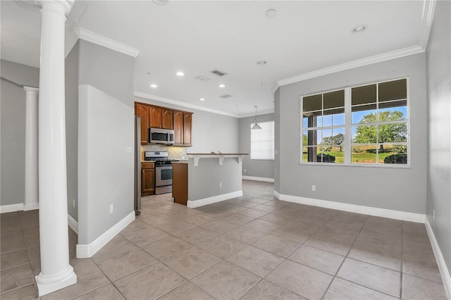 kitchen featuring backsplash, a kitchen island, appliances with stainless steel finishes, and ornate columns