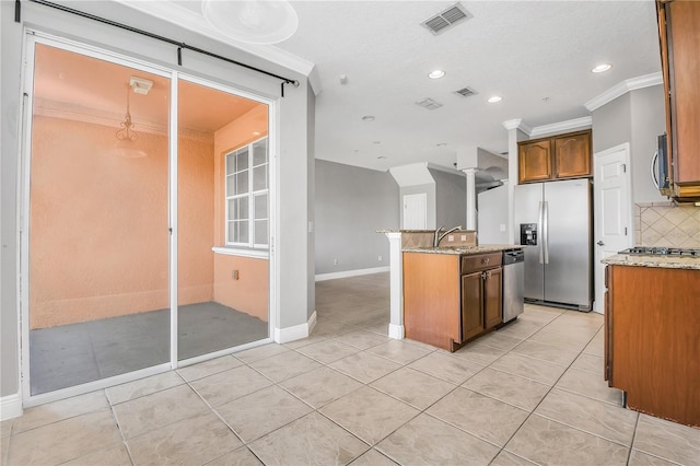 kitchen featuring stainless steel appliances, light tile floors, tasteful backsplash, light stone counters, and sink